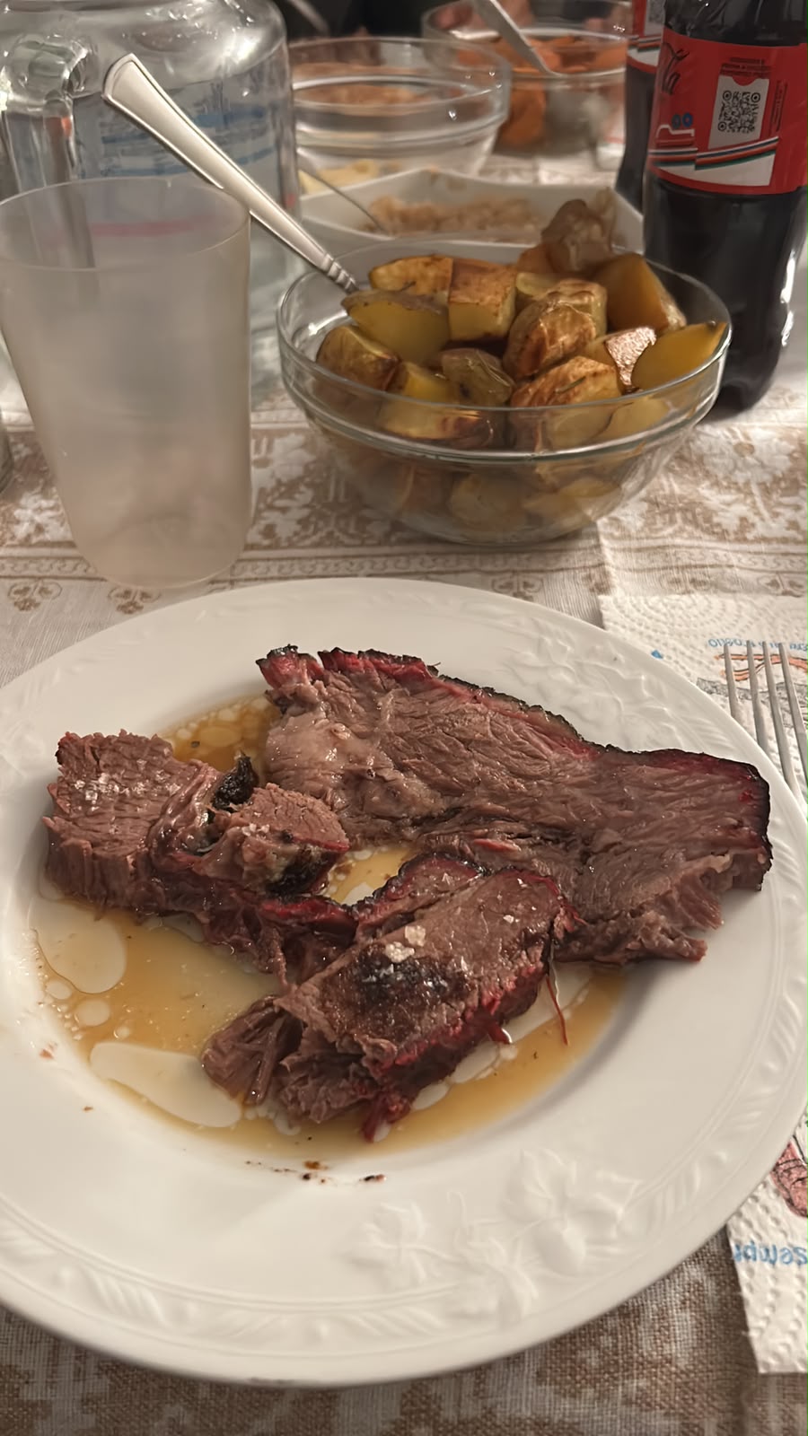 Brisket affettato servito con i suoi succhi e patate arrosto
